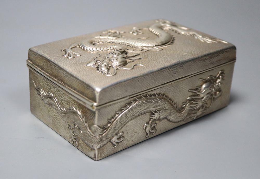An early 20th century Chinese Export white metal cigarette box, embossed with a dragon, by Wang Hing, 13cm, gross 9oz.